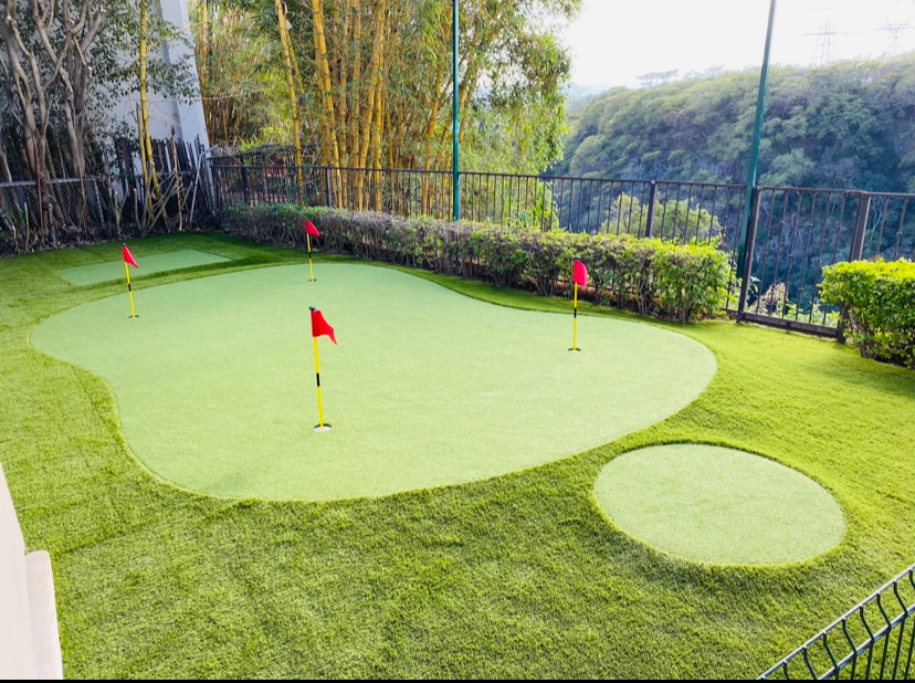 Putting green sintético en terraza con vista a bambú y montaña