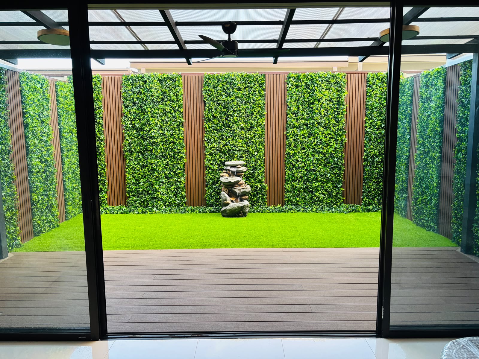 Patio interior con zacate sintético y jardín vertical