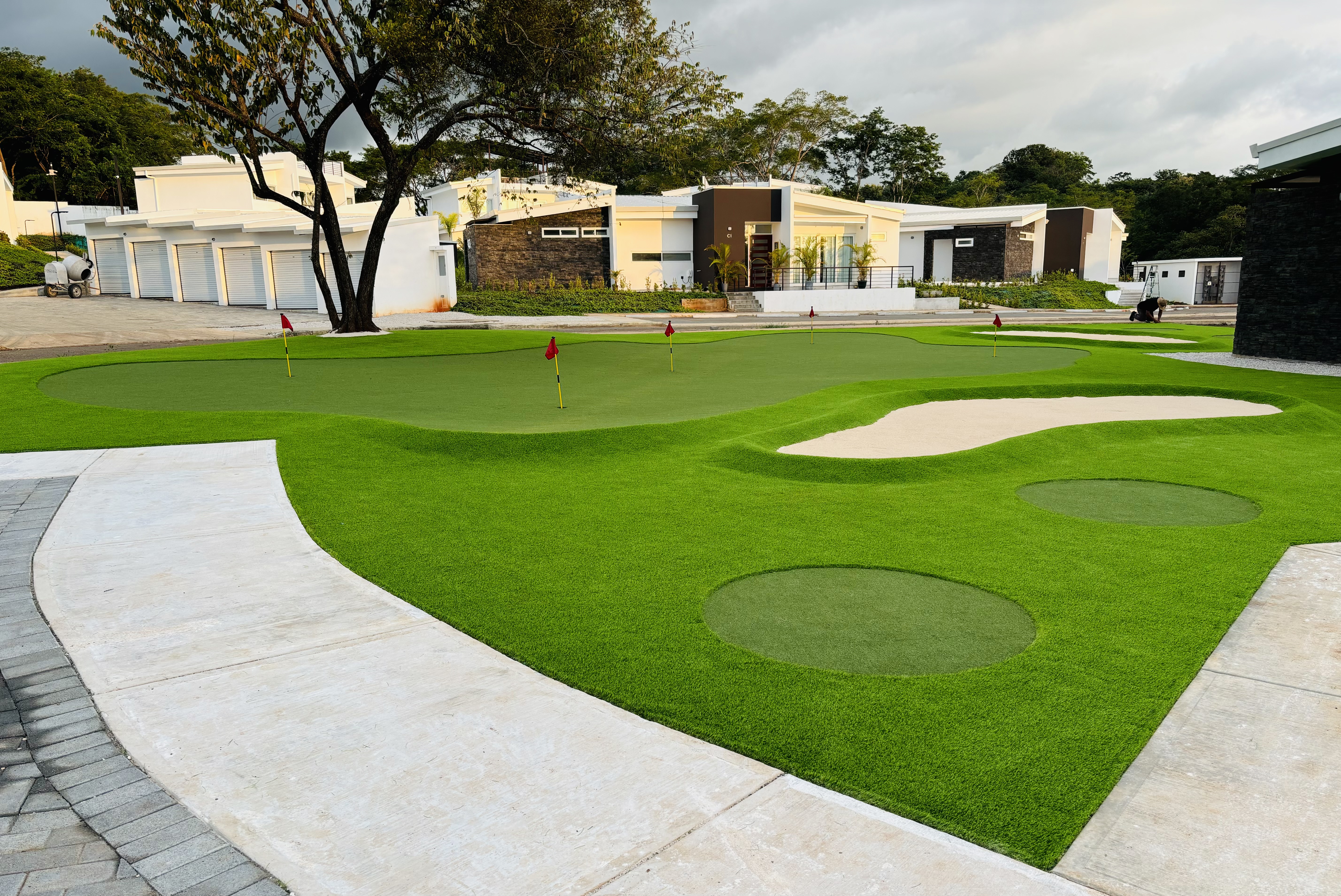 Putting green sintético con bunkers y múltiples banderas